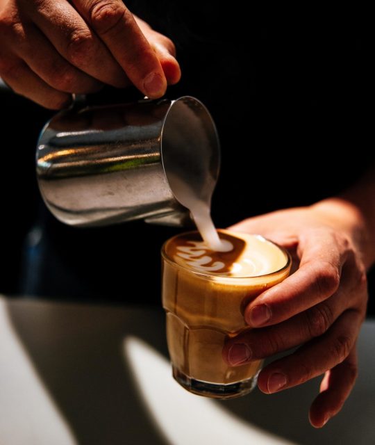 pouring some latte art in our specialty coffee bar